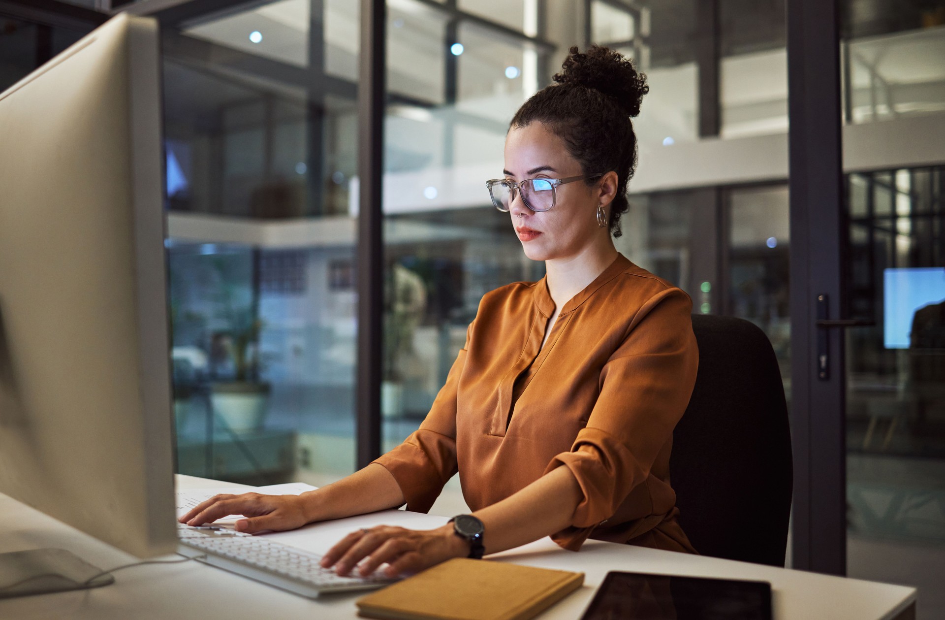 Computer, thinking or business woman in night office of digital marketing startup, advertising agency or creative Mexico company. Designer, worker and employee on technology for brand growth deadline